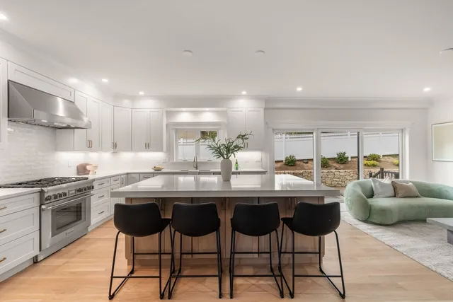 a kitchen with stainless steel appliances granite countertop a table and chairs in it