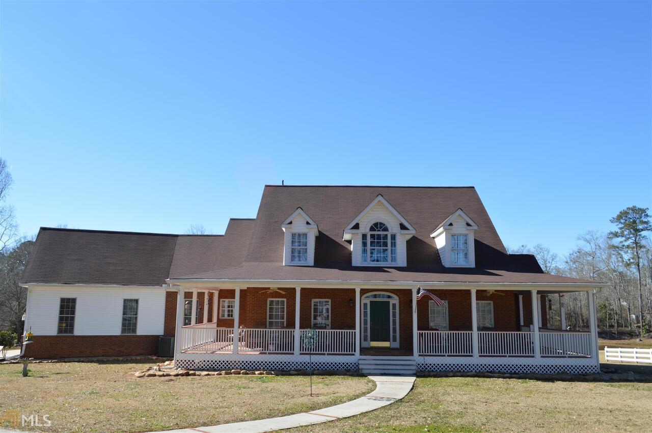 a view of a large white building with swimming pool in front of it