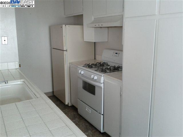 Pleasanton Pleasanton, CA 94588 - Photo 5 of 17 a kitchen with white cabinets and white appliances