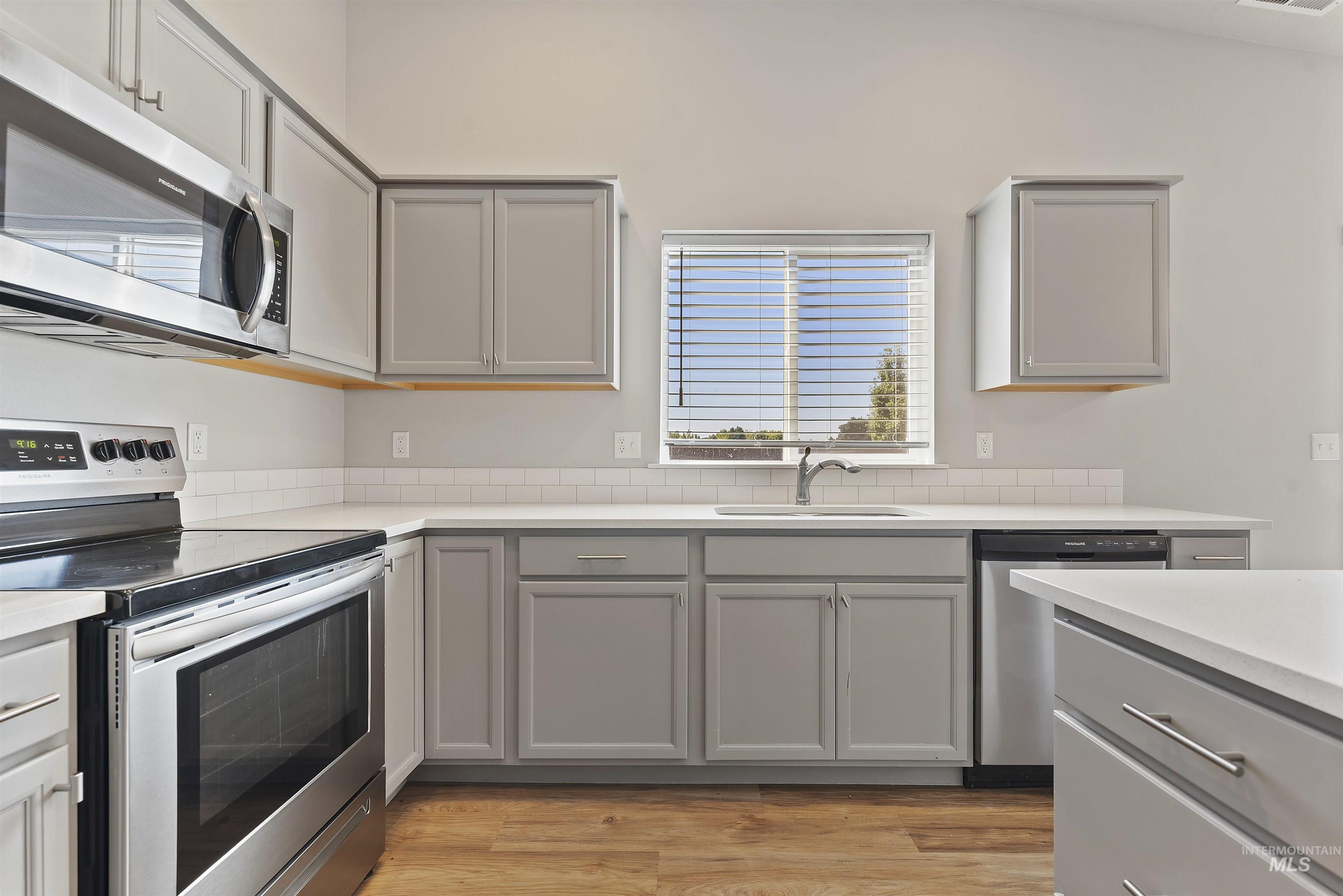 12703 West Fig Street Boise, ID 83713 - Photo 11 of 26 Kitchen featuring stainless steel appliances, gray cabinets, and light wood-style flooring