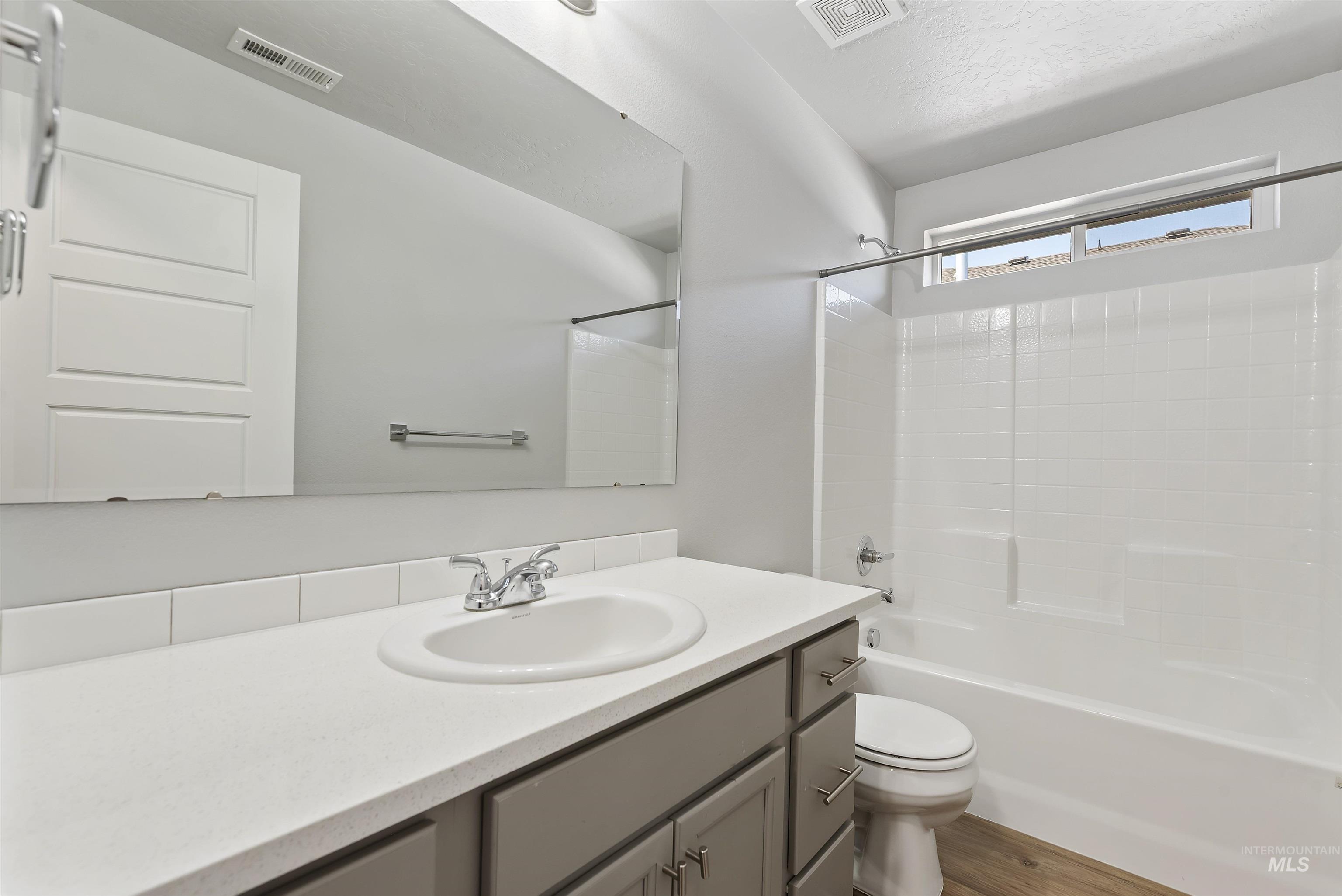 12703 West Fig Street Boise, ID 83713 - Photo 14 of 26 Bathroom with shower / washtub combination, vanity, wood finished floors, and a textured ceiling