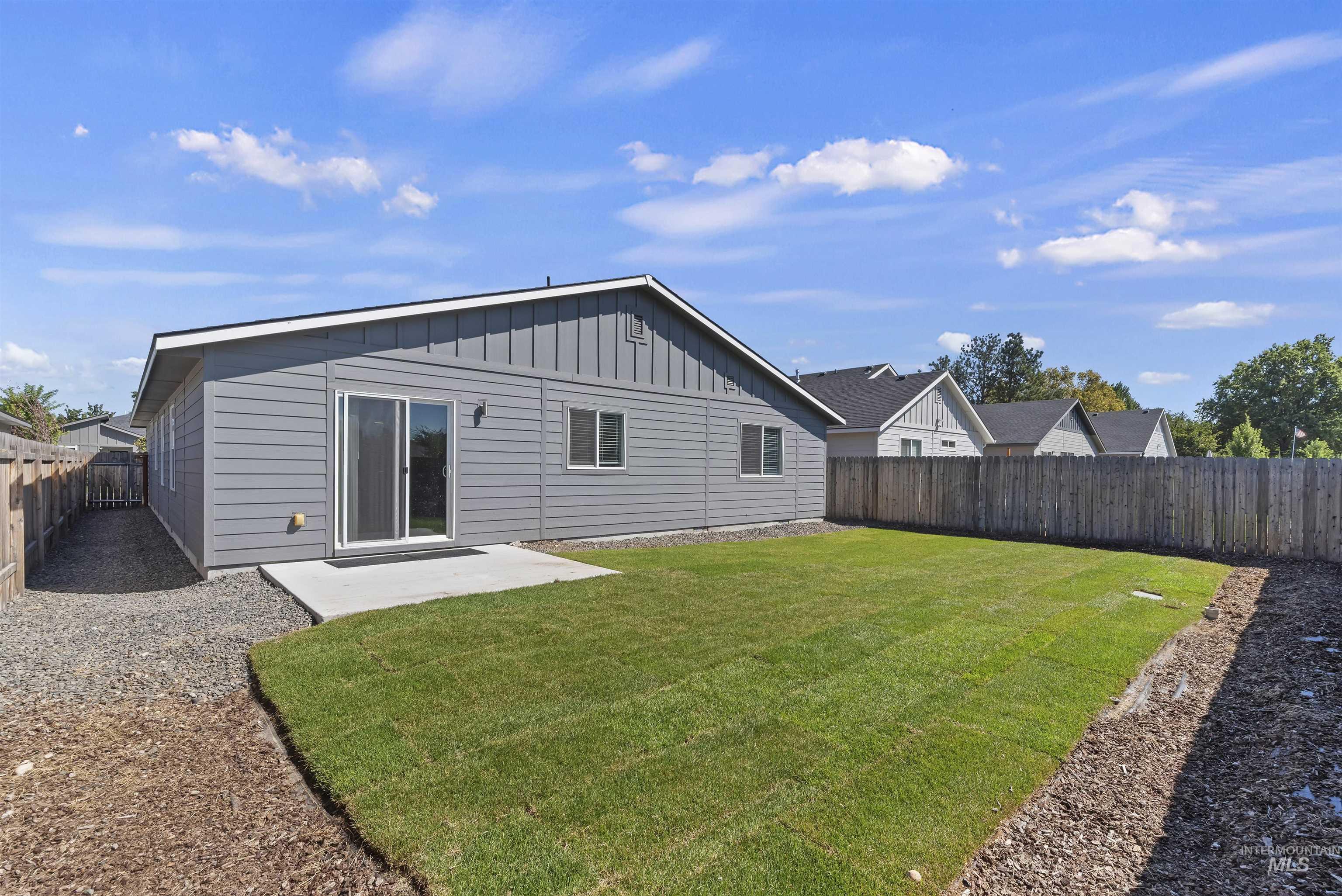 12703 West Fig Street Boise, ID 83713 - Photo 23 of 26 Rear view of property with a patio, a fenced backyard, and board and batten siding