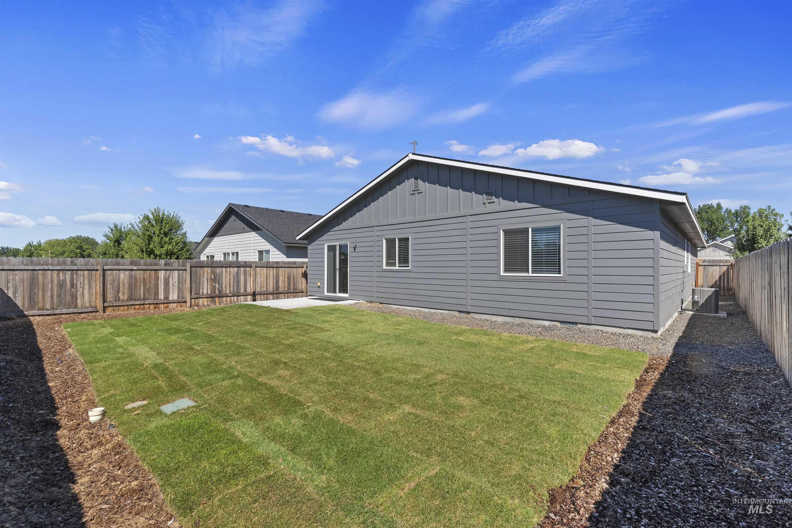12703 West Fig Street Boise, ID 83713 - Photo 25 of 26 Rear view of property featuring a patio area, a fenced backyard, and board and batten siding