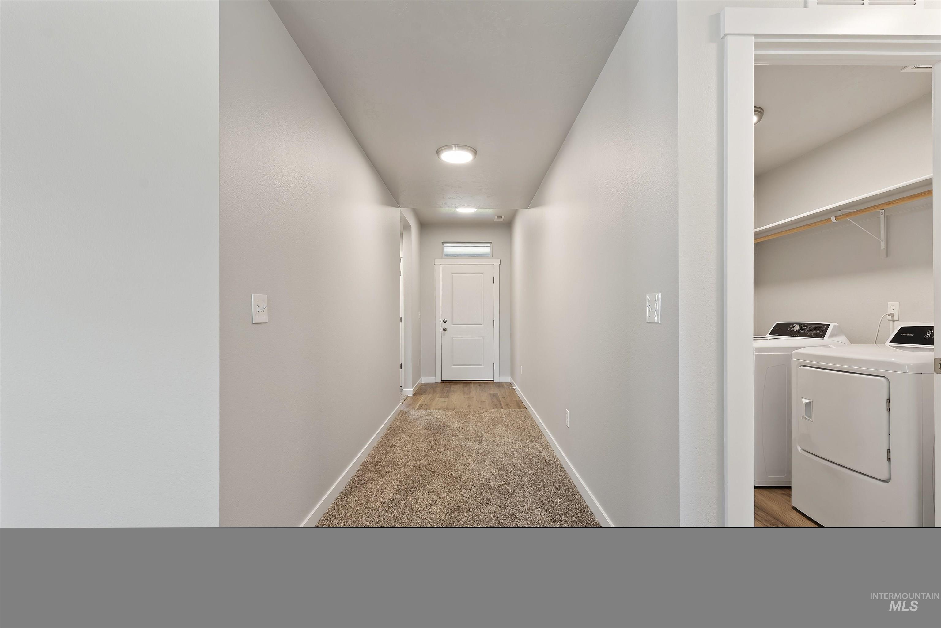 12703 West Fig Street Boise, ID 83713 - Photo 5 of 26 Hallway featuring light colored carpet and washer and dryer