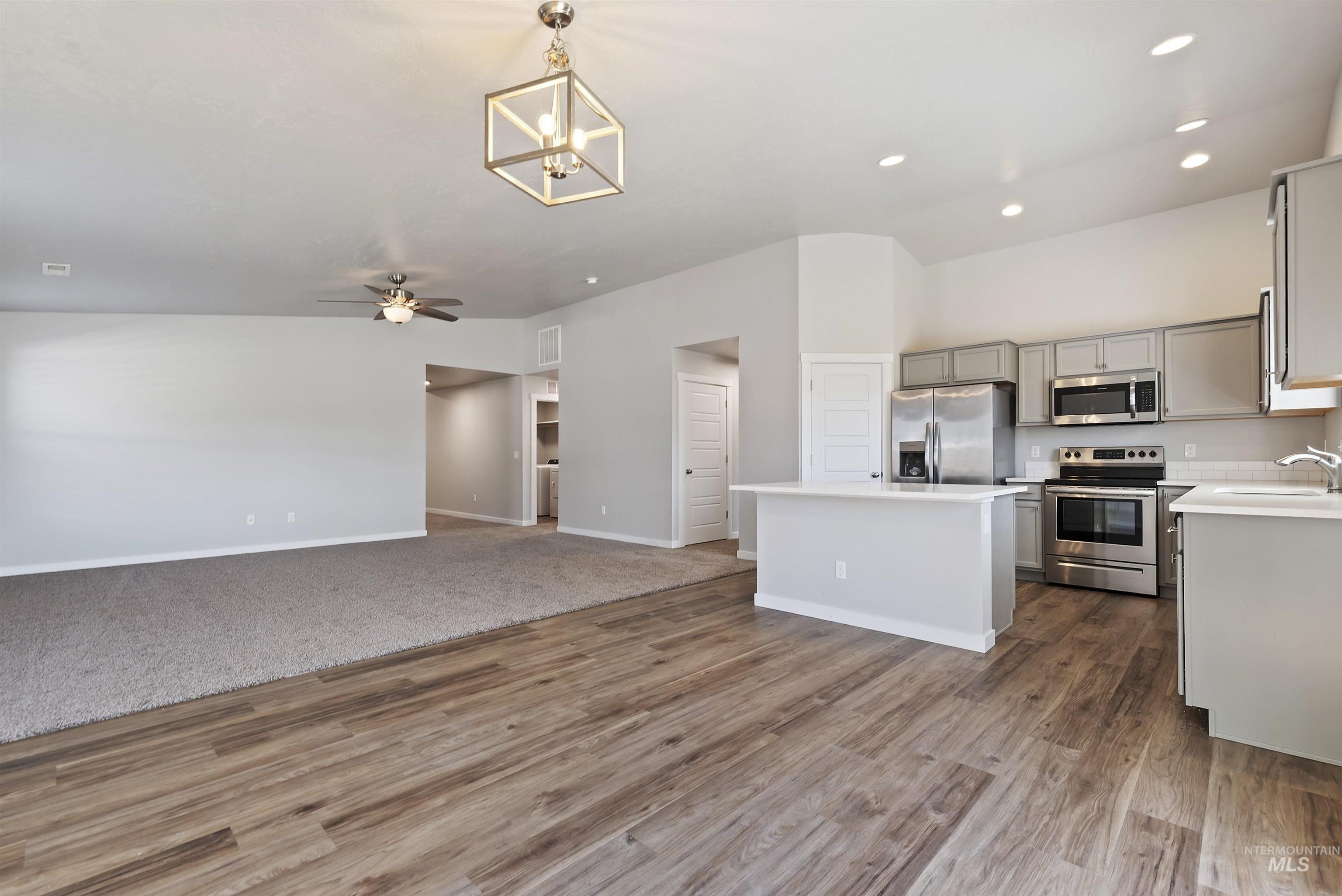12703 West Fig Street Boise, ID 83713 - Photo 26 of 26 Kitchen with decorative light fixtures, open floor plan, stainless steel appliances, a center island, and gray cabinets