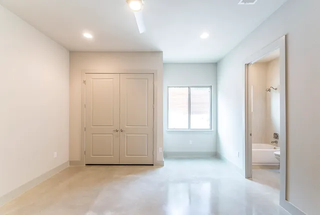 an empty room with windows and closet