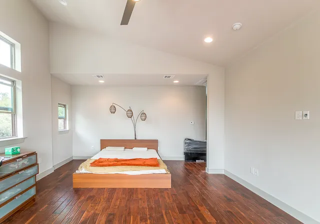 a bedroom with a bed and wooden floor