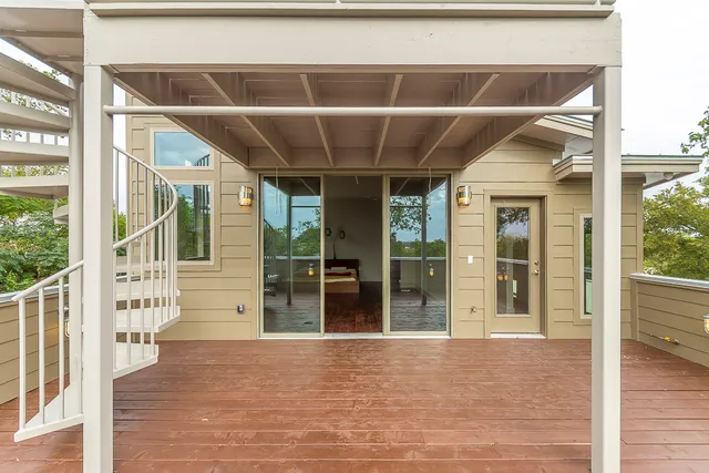a view of a balcony with wooden floor and floor to ceiling window