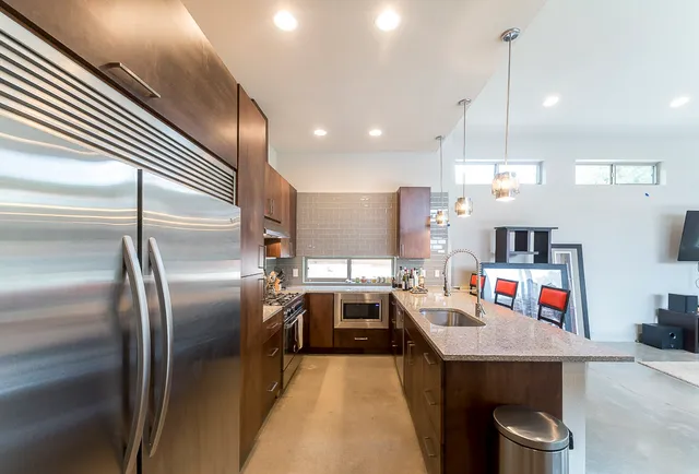 a kitchen with kitchen island a refrigerator and a sink