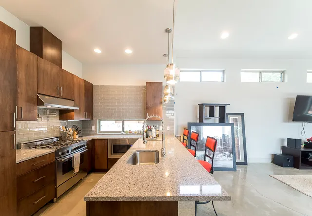 a kitchen with stainless steel appliances granite countertop a sink a stove and a refrigerator