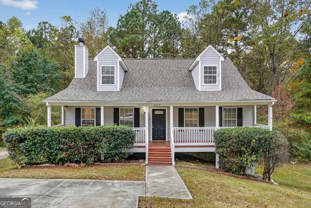 a front view of a house with a yard and potted plants