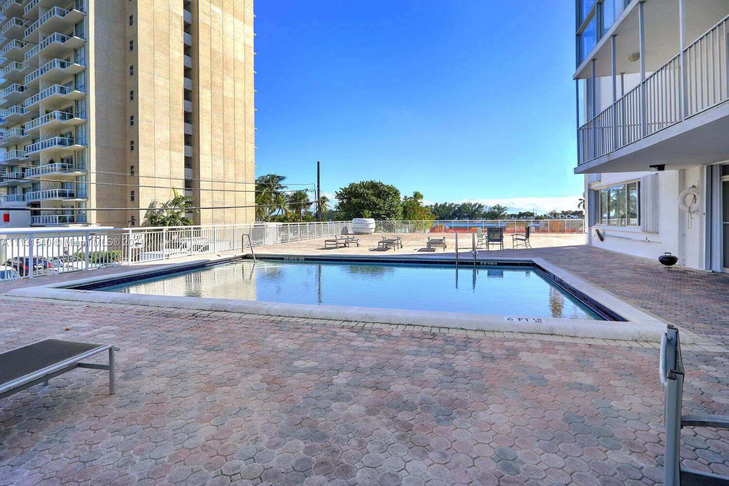 145 Southeast 25th Road, Unit 502 Miami, FL 33129 - Photo 22 of 24 a swimming pool with outdoor seating and yard