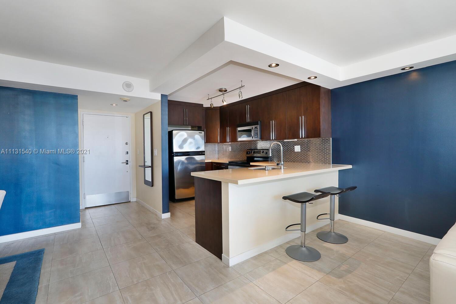 145 Southeast 25th Road, Unit 502 Miami, FL 33129 - Photo 8 of 24 a kitchen with stainless steel appliances kitchen island granite countertop a refrigerator and a sink