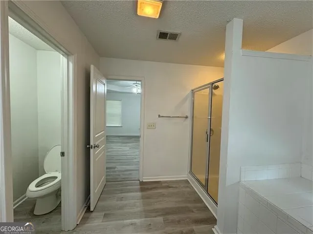 a bathroom with a granite countertop toilet a sink and shower