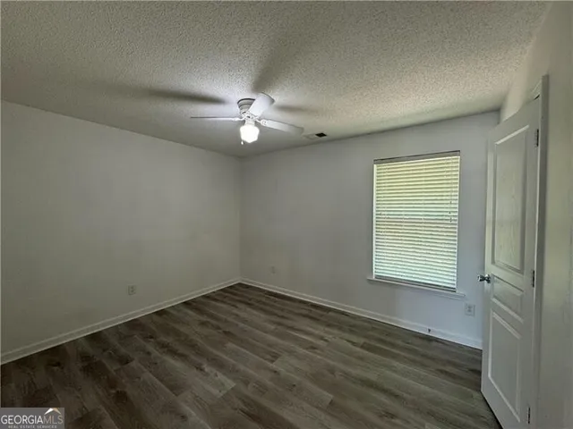 an empty room with wooden floor and window
