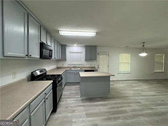 a kitchen with stainless steel appliances granite countertop a stove a sink and a refrigerator