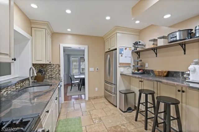a kitchen with granite countertop a sink appliances cabinets and furniture