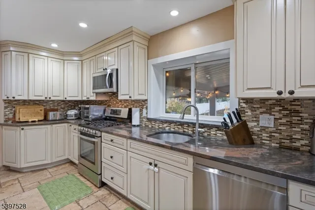 a kitchen with stainless steel appliances granite countertop a sink a stove and a granite counter tops