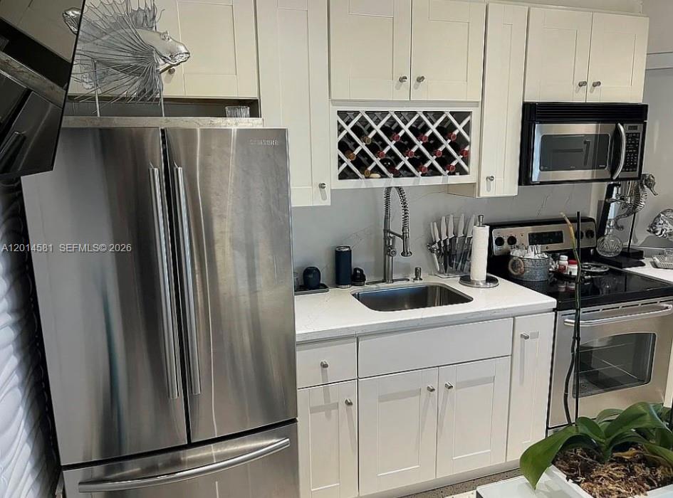 3400 North Surf Road, Unit 1 Hollywood, FL 33019 - Photo 6 of 14 a kitchen with stainless steel appliances a refrigerator sink and microwave