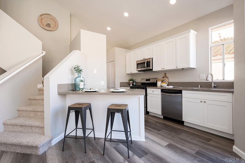 1340 Serena Circle, Unit 1 Chula Vista, CA 91910 - Photo 11 of 31 a kitchen with a sink a microwave and cabinets