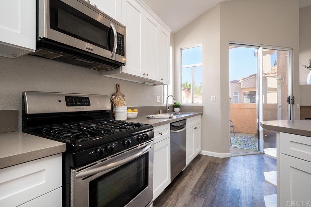 1340 Serena Circle, Unit 1 Chula Vista, CA 91910 - Photo 12 of 31 a kitchen with stainless steel appliances a stove a microwave and cabinets