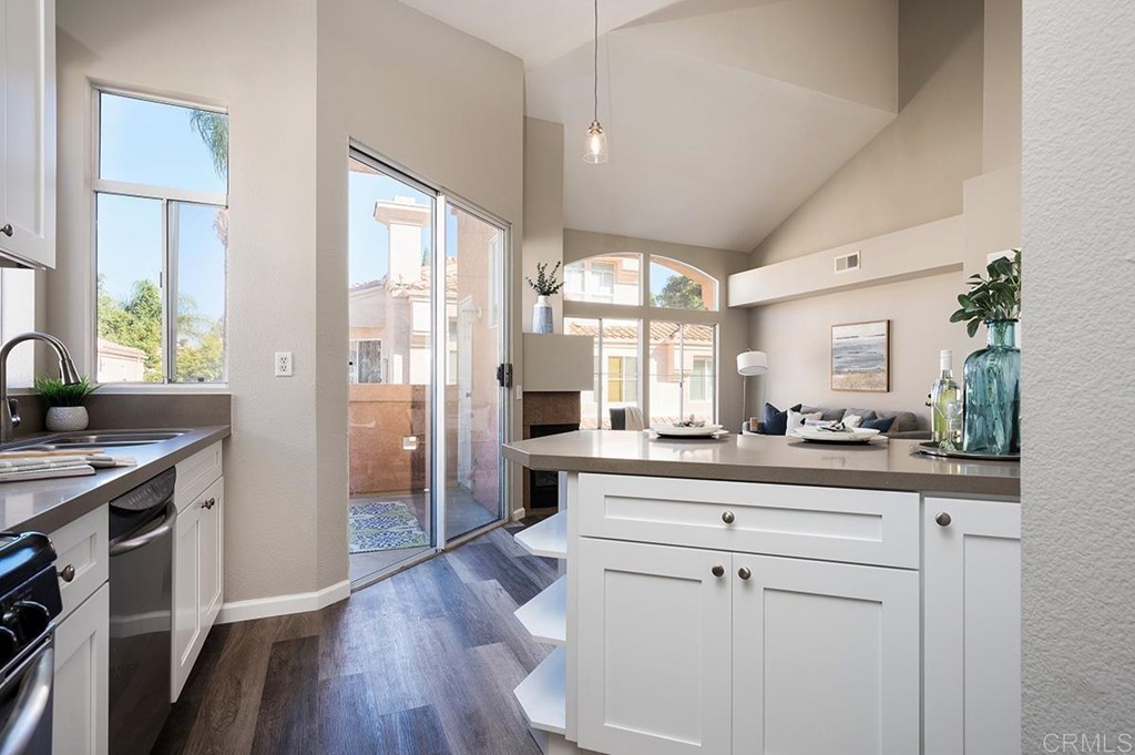 1340 Serena Circle, Unit 1 Chula Vista, CA 91910 - Photo 13 of 31 a kitchen with white cabinets and wooden floor
