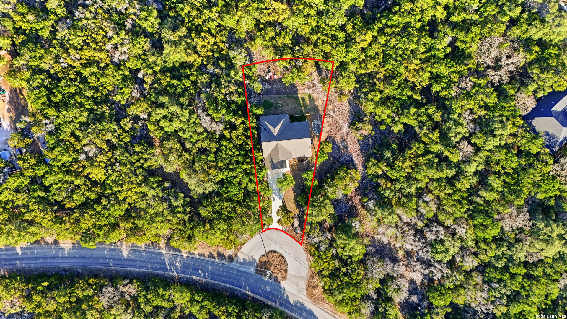2295 Tanglewood Trail Spring Branch, TX 78070 - Photo 37 of 37 a view of a yard with plants and a bench