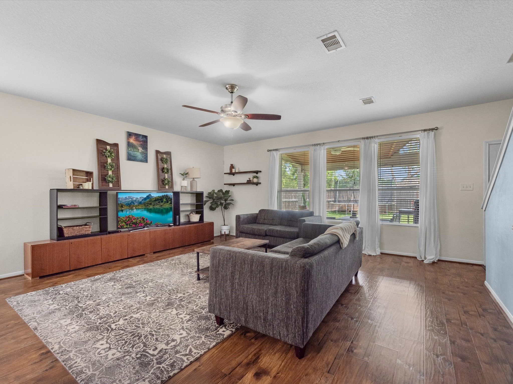 22422 Lamaster Lane Spring, TX 77373 - Photo 6 of 35 Spacious living room features laminate floors, a ceiling fan and a view of the backyard.