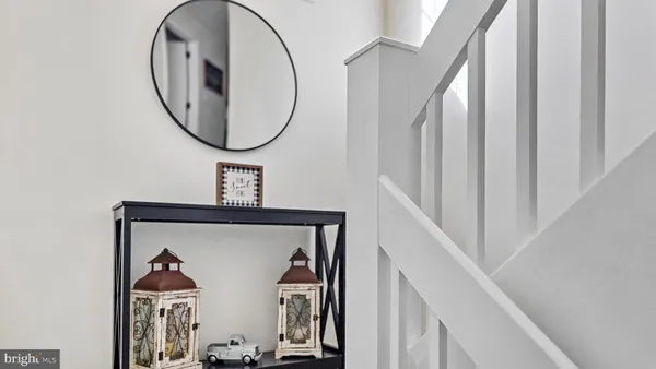 a view of staircase with wooden floor and mirror