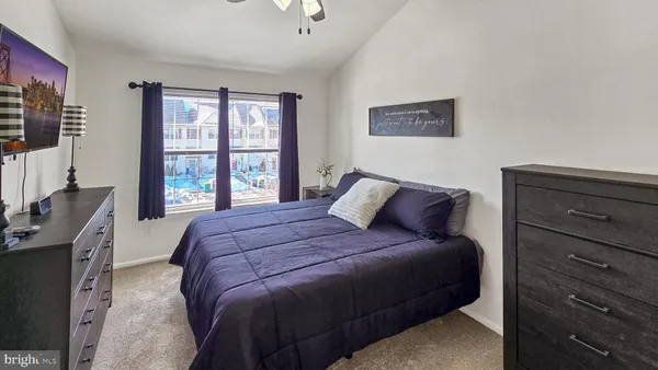 a bedroom with a large bed and a flat tv screen on dresser