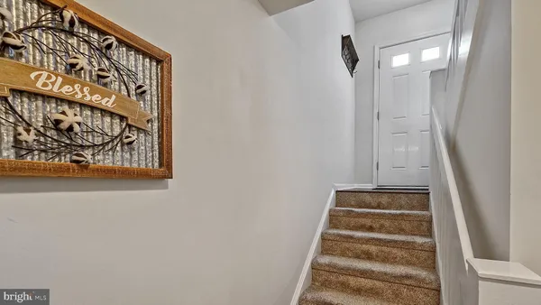 a view of staircase with white walls and a window