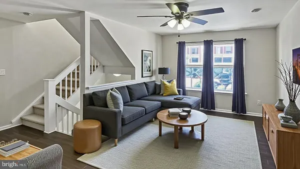 a living room with furniture a ceiling fan and a rug
