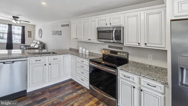 a kitchen with white cabinets and stainless steel appliances