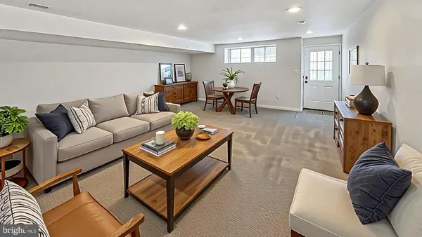 a living room with furniture two window and a flat screen tv