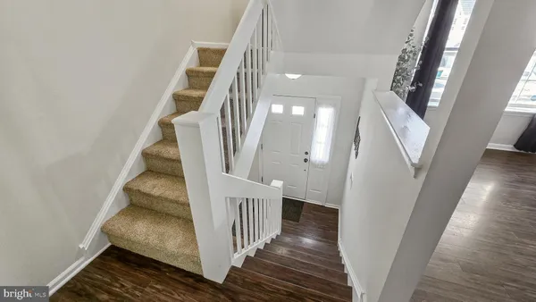 a view of a hallway with wooden floor and entryway