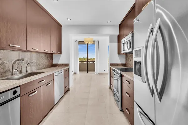 a kitchen with stainless steel appliances granite countertop a refrigerator and a sink