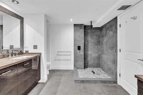 a bathroom with a sink mirror and shower