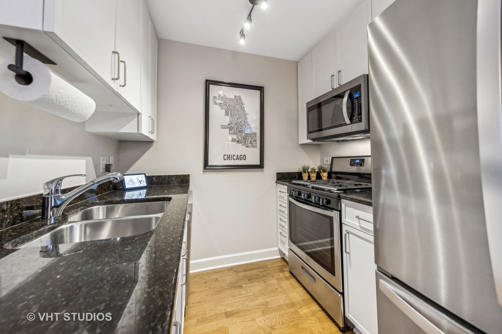 680 North Green Street, Unit 413 Chicago, IL 60642 - Photo 9 of 12 a kitchen with stainless steel appliances granite countertop a sink stove and refrigerator