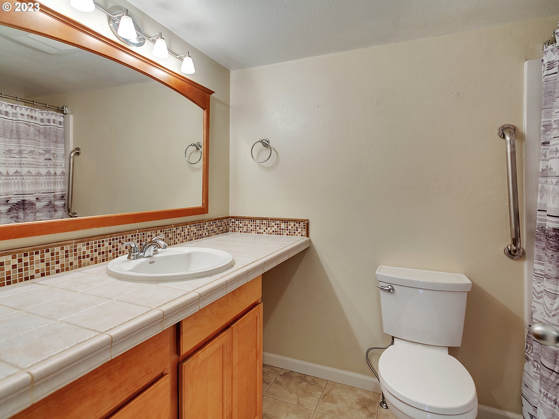 5715 Southwest Pendleton Street Portland, OR 97221 - Photo 12 of 31 a bathroom with a granite countertop toilet sink and mirror