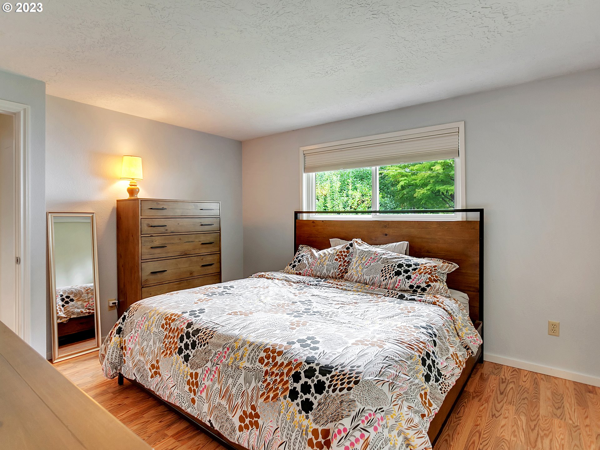 5715 Southwest Pendleton Street Portland, OR 97221 - Photo 14 of 31 a bedroom with a large bed and a dresser