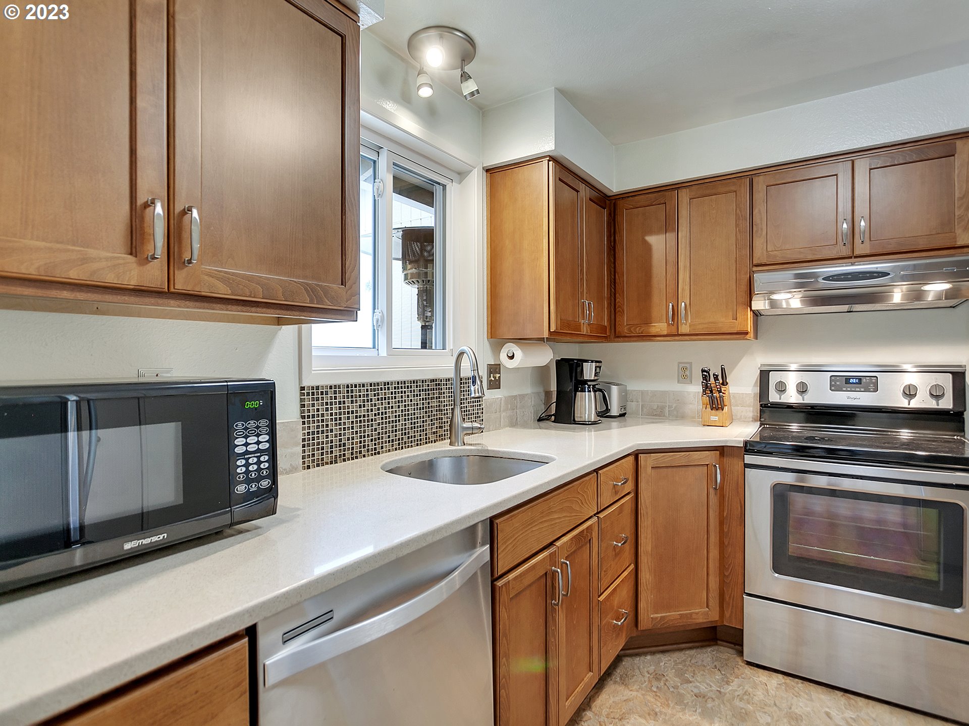 5715 Southwest Pendleton Street Portland, OR 97221 - Photo 7 of 31 a kitchen with granite countertop a sink stainless steel appliances and cabinets