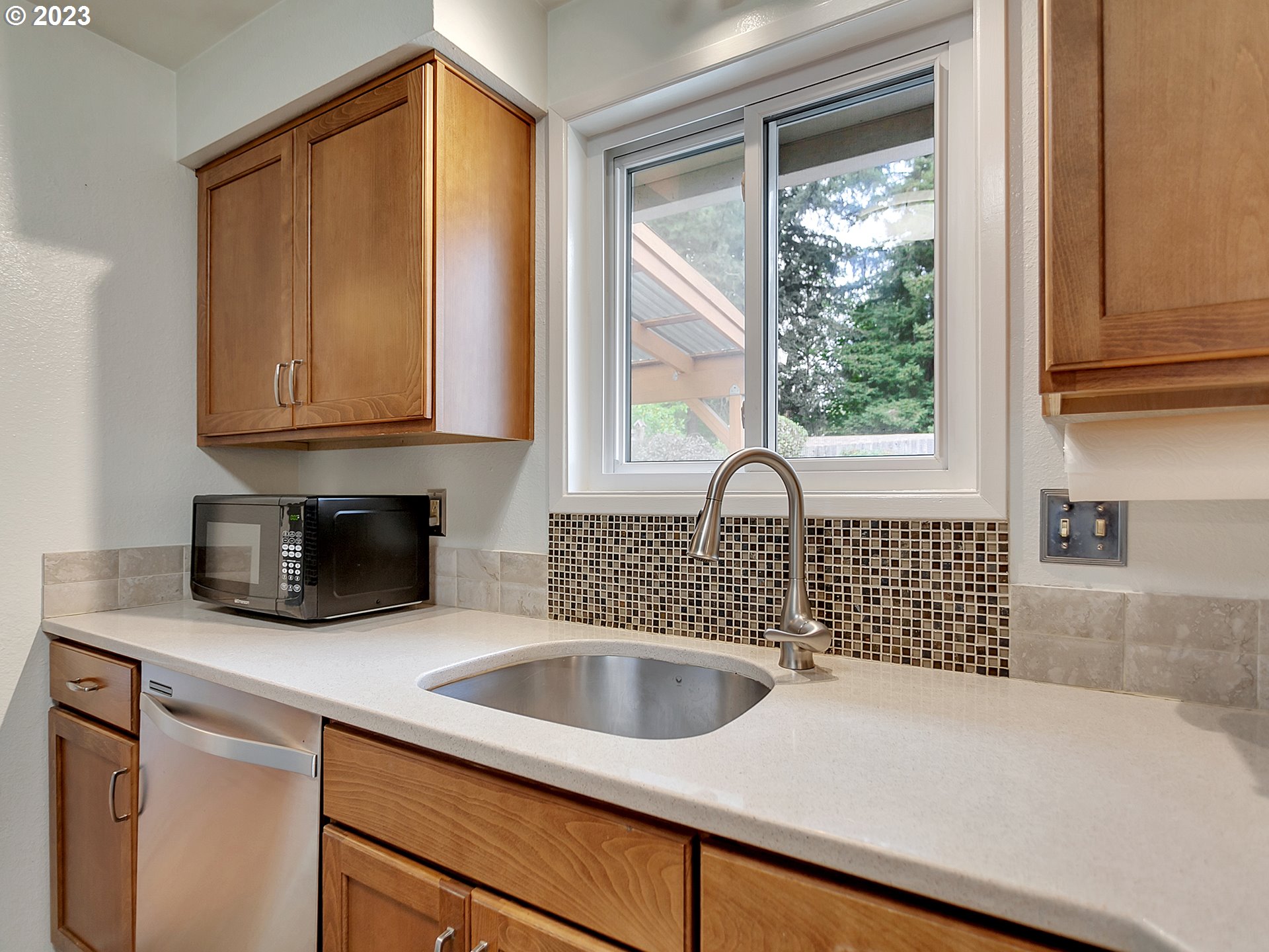5715 Southwest Pendleton Street Portland, OR 97221 - Photo 9 of 31 a kitchen with granite countertop a sink a stove and a microwave