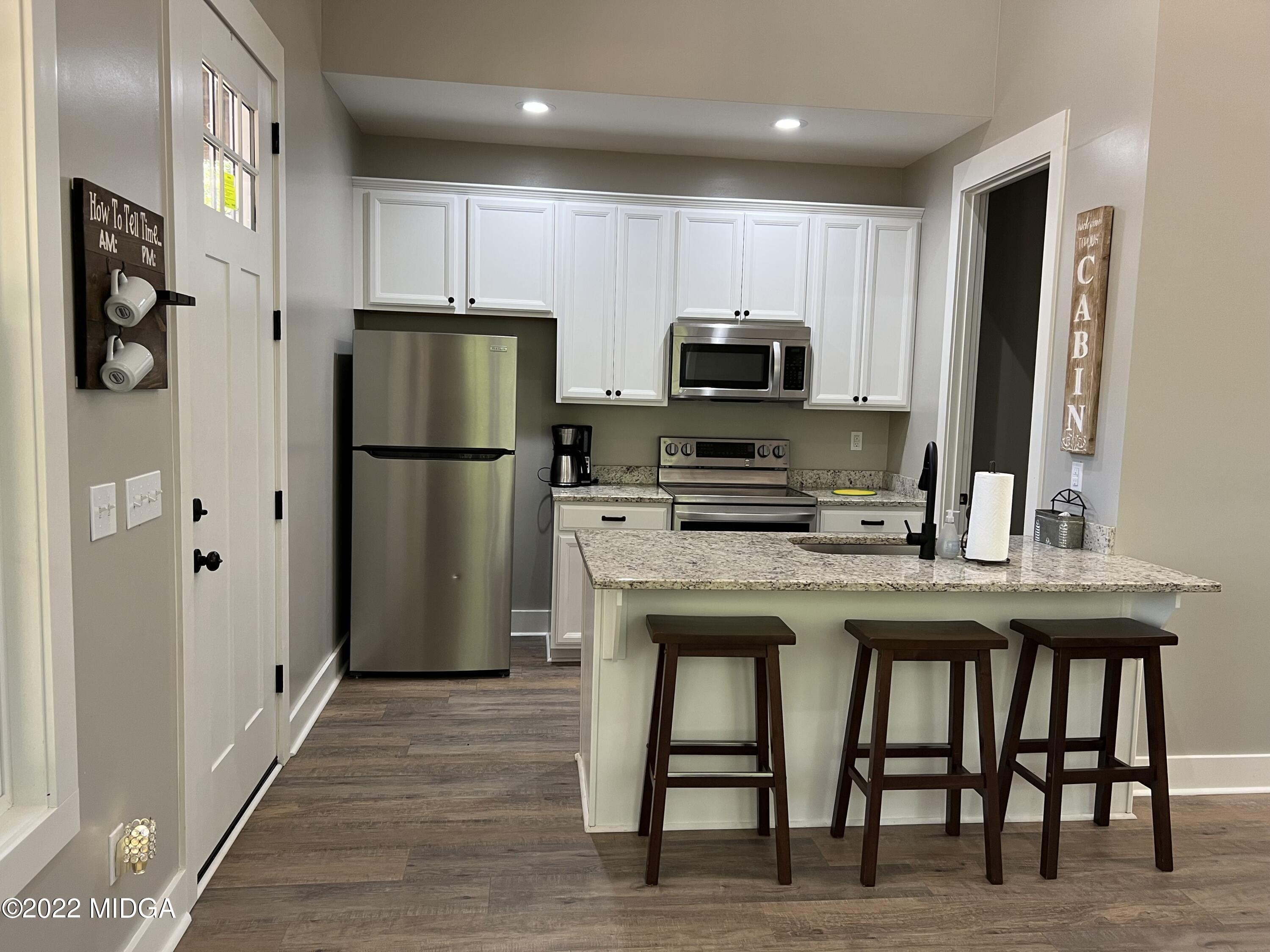 142 Towaliga Road Forsyth, GA 31029 - Photo 3 of 21 a kitchen with refrigerator cabinets and wooden floor