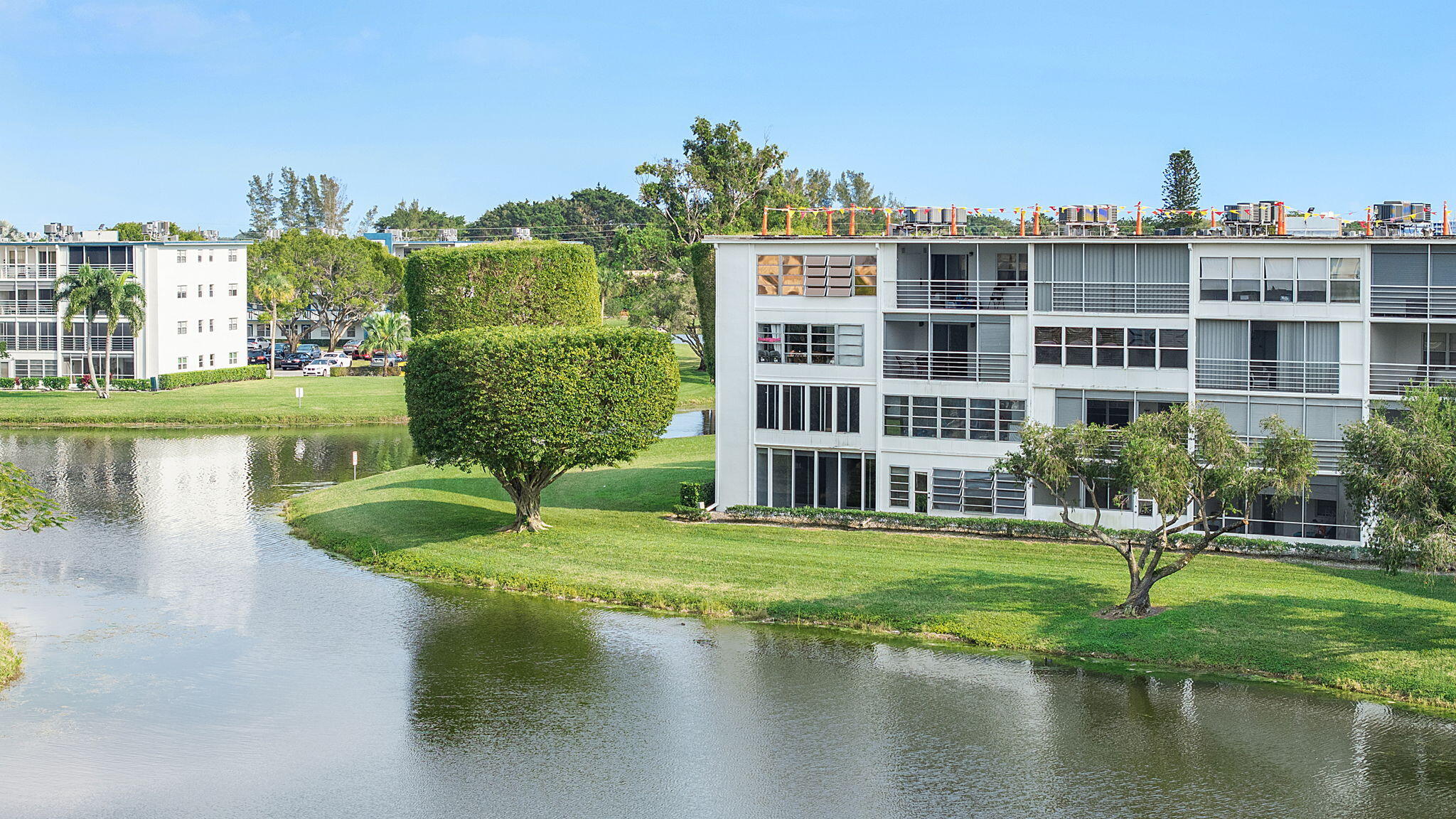 1037 Guilford C Boca Raton, FL 33434 - Photo 27 of 35 a view of a lake with a building and yard with green space