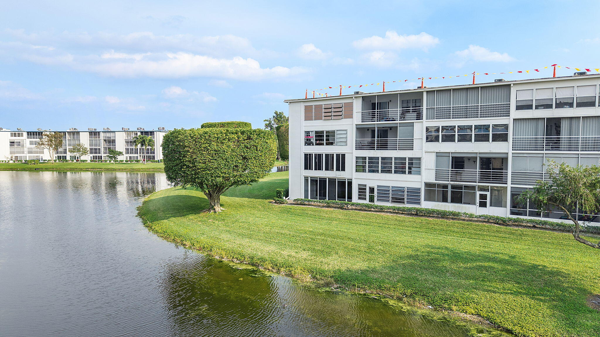 1037 Guilford C Boca Raton, FL 33434 - Photo 28 of 35 a view of a large building with a yard