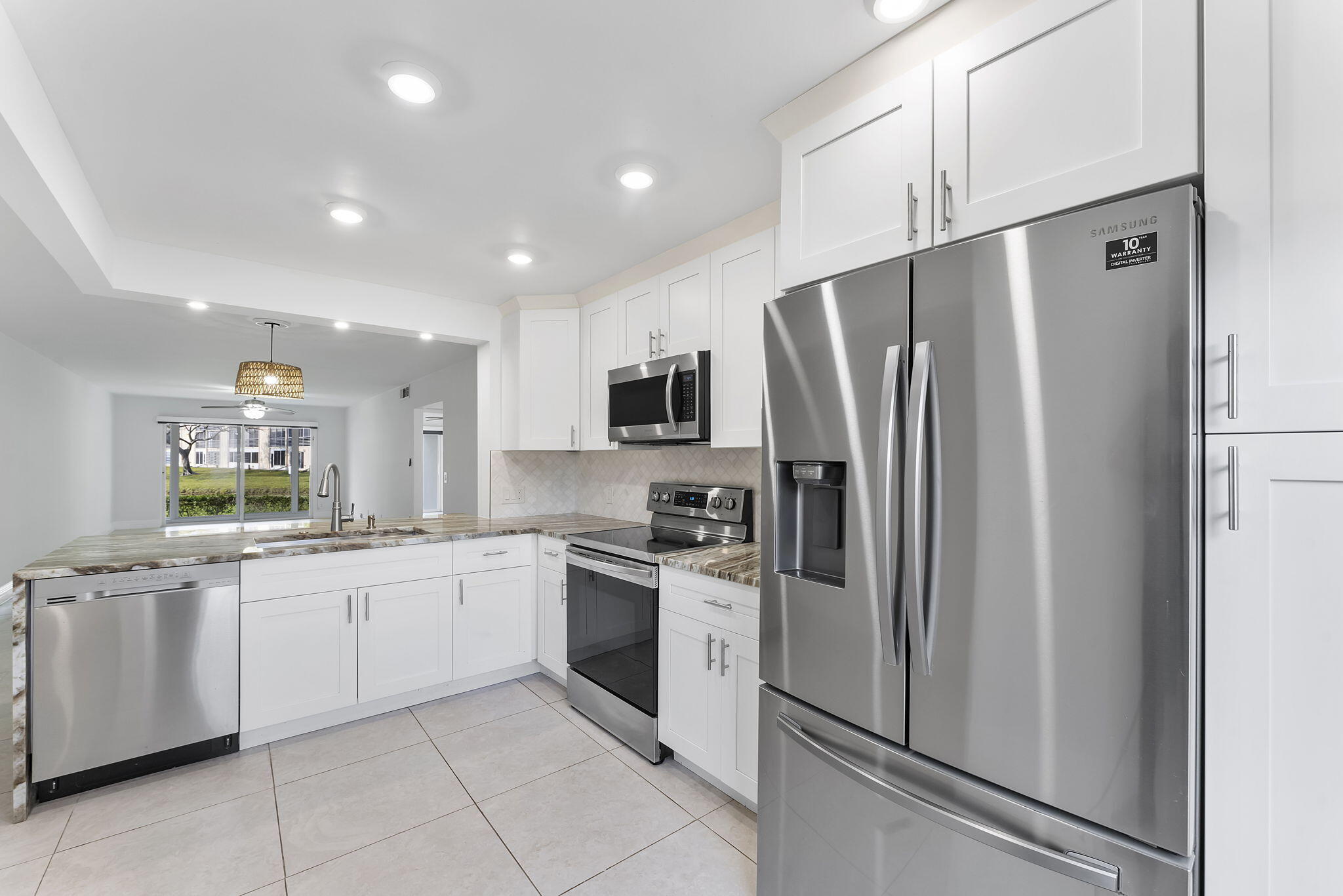 1037 Guilford C Boca Raton, FL 33434 - Photo 6 of 35 a kitchen with white cabinets sink and refrigerator