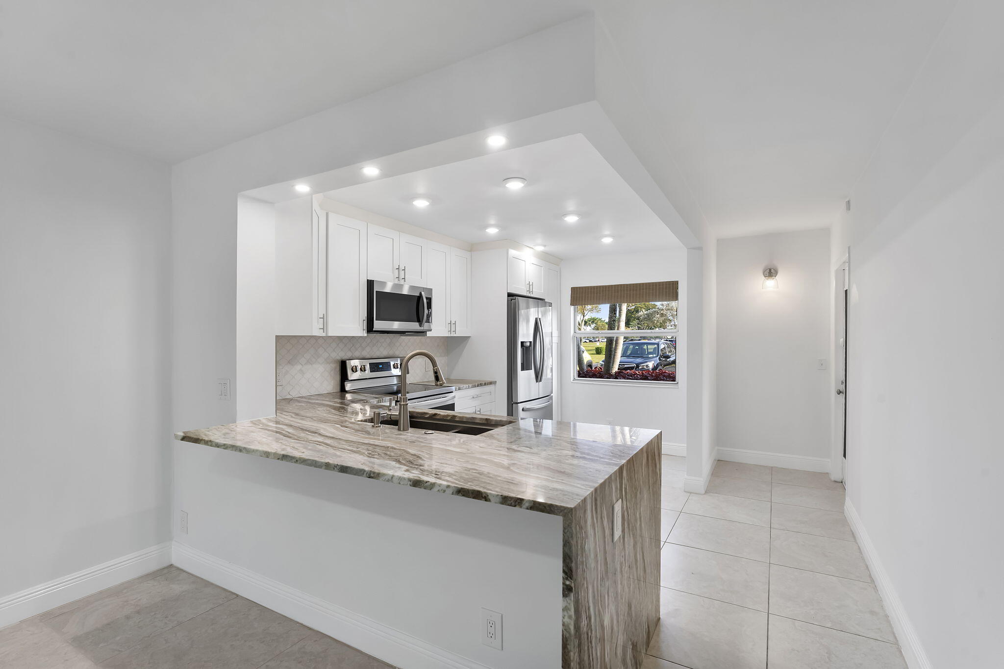 1037 Guilford C Boca Raton, FL 33434 - Photo 9 of 35 a kitchen with granite countertop kitchen island sink and refrigerator