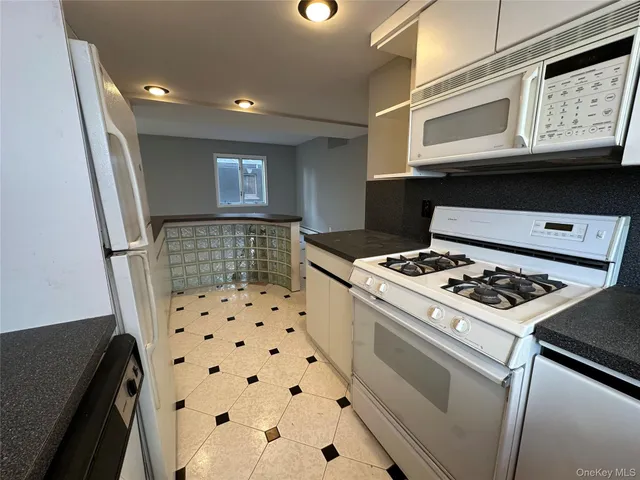 a kitchen with stove and white cabinets