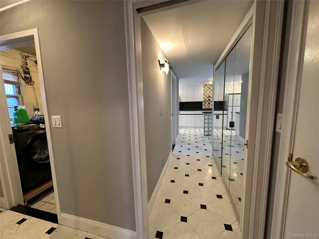 a view of a hallway to a livingroom with furniture and a window