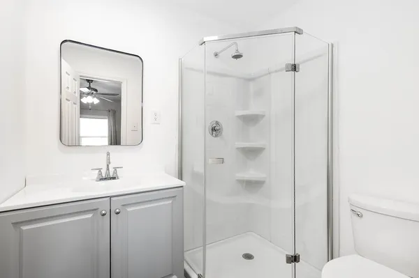 a bathroom with a shower sink vanity and mirror